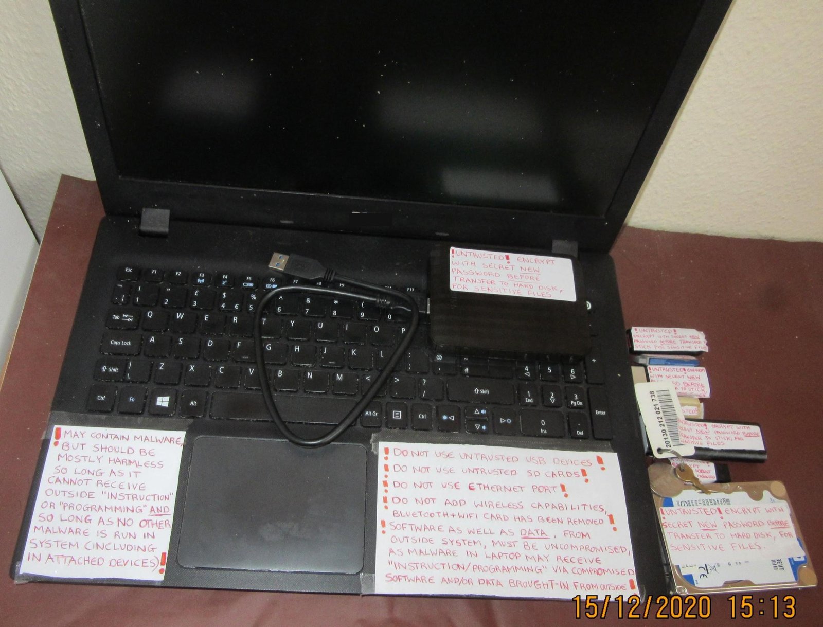 Potentially-compromised laptop, hard disks, and memory sticks, with labels instructing as to how to use them safely